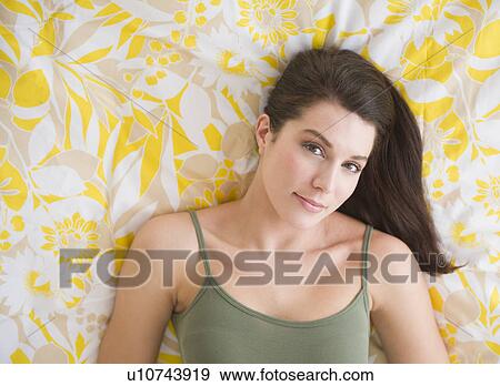 Portrait of beautiful woman lying on bed View Large Photo Image Stock Photo - Portrait of beautiful woman lying on bed. Fotosearch
