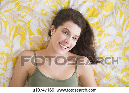 Portrait of beautiful woman lying on bed View Large Photo Image Stock Photo - Portrait of beautiful woman lying on bed. Fotosearch