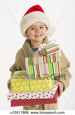 Portrait of boy (4-5) carrying christmas presents View Large Photo Image Stock Photo - Portrait of boy (4-5) carrying christmas presents. Fotosearch
