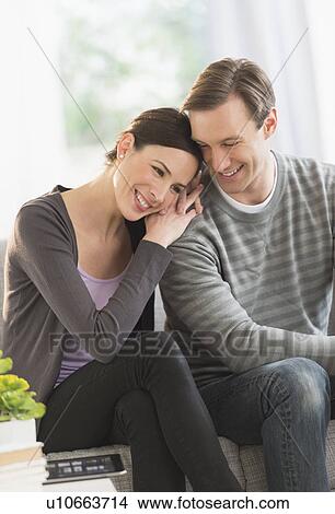 Portrait of couple sitting on sofa View Large Photo Image Picture - Portrait of couple sitting on sofa. Fotosearch