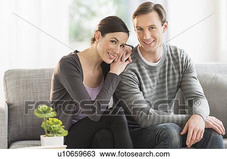 Portrait of couple sitting on sofa View Large Photo Image Stock Image - Portrait of couple sitting on sofa. Fotosearch