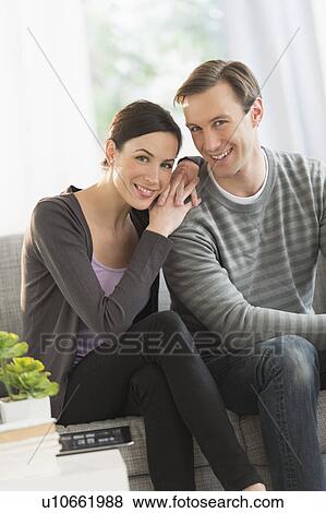 Portrait of couple sitting on sofa View Large Photo Image Stock Photo - Portrait of couple sitting on sofa. Fotosearch