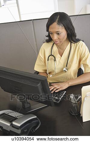 Portrait of female nurse at station View Large Photo Image Picture - Portrait of female nurse at station. Fotosearch