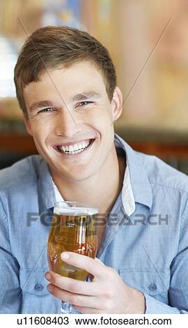 Portrait of man holding glass of beer View Large Photo Image Stock Image - Portrait of man holding glass of beer. Fotosearch