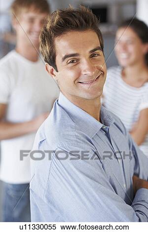 Stock Photography - Portrait of man with coworkers in background. Fotosearch