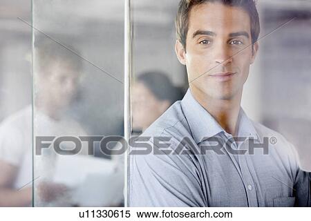 Portrait of man with coworkers in background View Large Photo Image Stock Photography - Portrait of man with coworkers in background. Fotosearch