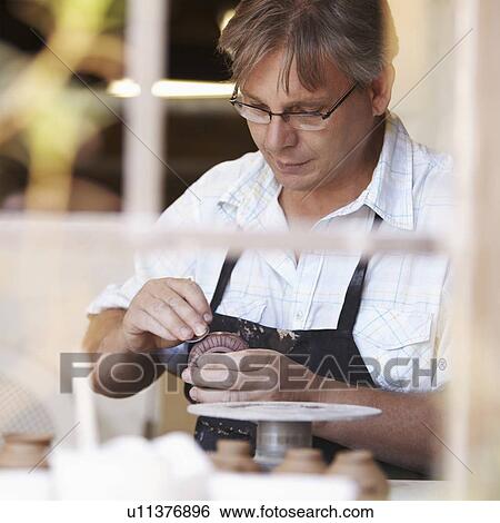 Portrait of mature man decorating clay vase View Large Photo Image Stock Photograph - Portrait of mature man decorating clay vase. Fotosearch