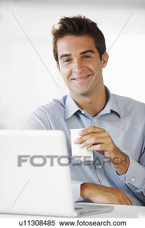 Stock Photography - Portrait of mid adult man holding coffee cup. Fotosearch