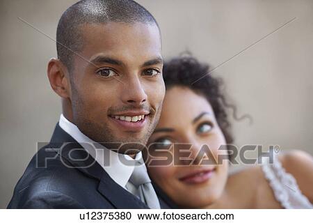 Stock Image - Portrait of newly wed couple, focus on groom. Fotosearch