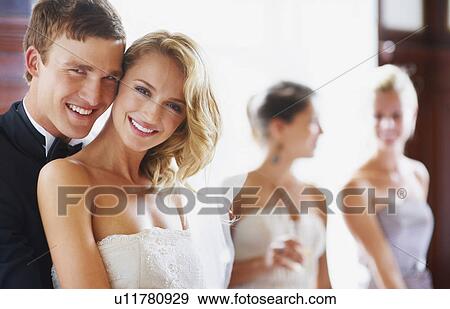Portrait of newly wed couple, bridesmaids in background View Large Photo Image Stock Photo - Portrait of newly wed couple, bridesmaids in background. Fotosearch