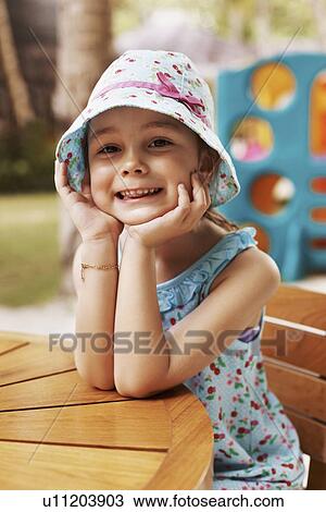 Portrait of smiling girl (6-7) sitting at table View Large Photo Image Stock Image - Portrait of smiling girl (6-7) sitting at table. Fotosearch