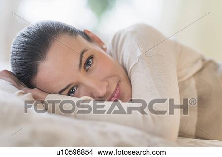 Picture - Portrait of woman lying on bed. Fotosearch