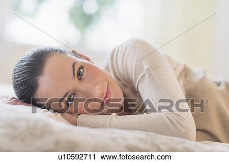 Portrait of woman lying on bed View Large Photo Image Stock Image - Portrait of woman lying on bed. Fotosearch