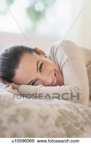 Portrait of woman lying on bed View Large Photo Image Stock Photo - Portrait of woman lying on bed. Fotosearch