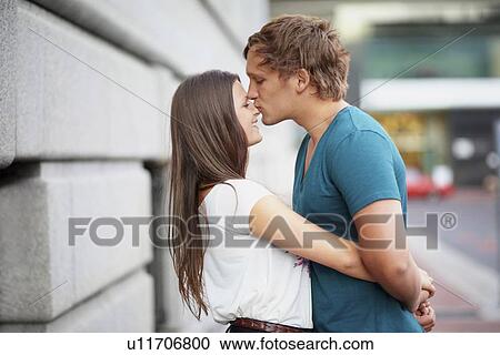 Stock Image - Portrait of young couple hugging . Fotosearch