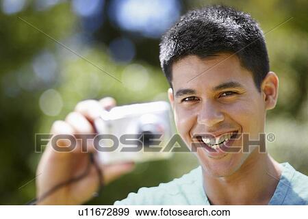 Portrait of young man using digital camera View Large Photo Image Stock Photo - Portrait of young man using digital camera. Fotosearch