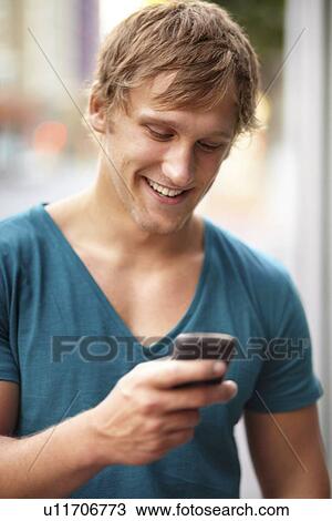 Portrait of young man using mobile phone View Large Photo Image Stock Image - Portrait of young man using mobile phone. Fotosearch