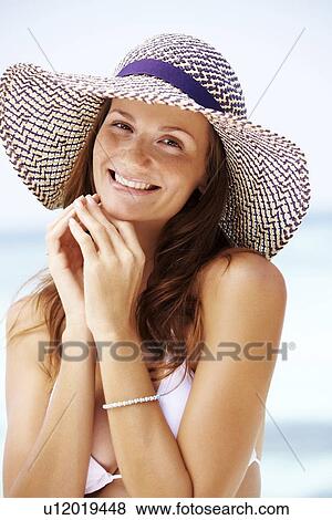 Stock Photo - Portrait of young woman in bikini and straw hat. Fotosearch