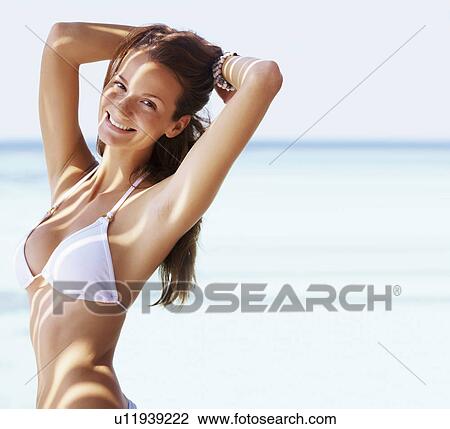 Portrait of young woman in bikini, hands behind head View Large Photo Image Stock Image - Portrait of young woman in bikini, hands behind head. Fotosearch