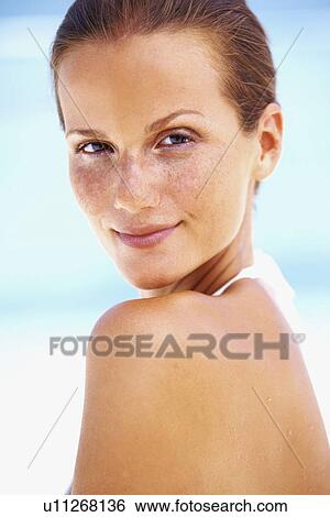 Portrait of young woman looking over shoulder View Large Photo Image Stock Photograph - Portrait of young woman looking over shoulder. Fotosearch