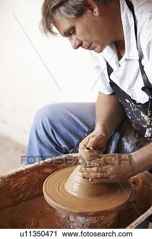 Stock Image - Potter concentrating on his work. Fotosearch