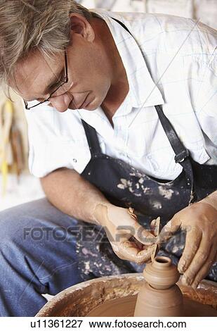 Stock Photo - Potter concentrating on his work. Fotosearch