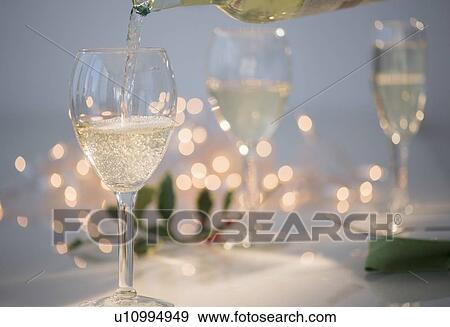 Pouring white wine into glasses View Large Photo Image Stock Photo - Pouring white wine into glasses. Fotosearch
