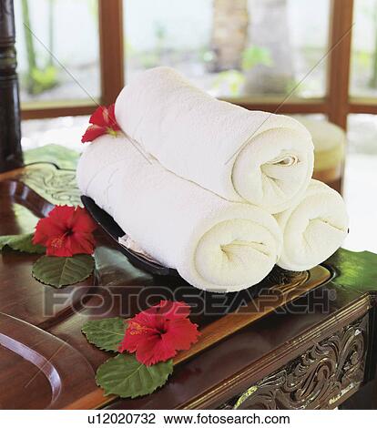 Stock Image - Rolled up towels in spa. Fotosearch