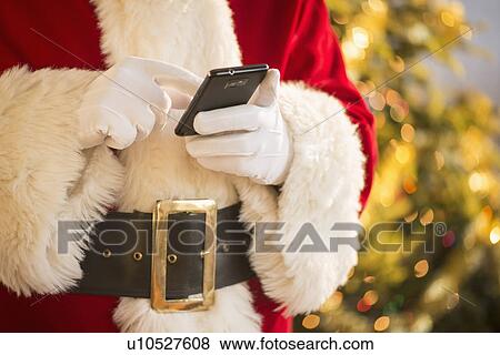 Stock Photo - Santa claus holding cell phone. Fotosearch