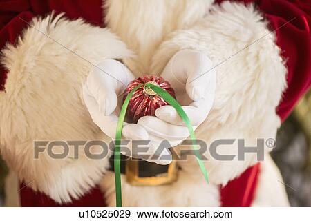 Santa claus holding gift View Large Photo Image Stock Photo - Santa claus holding gift. Fotosearch