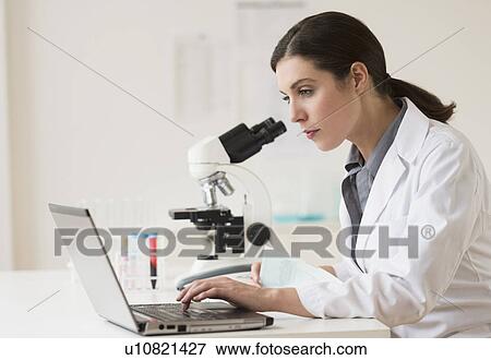 Stock Photo - Scientist looking through microscope. Fotosearch
