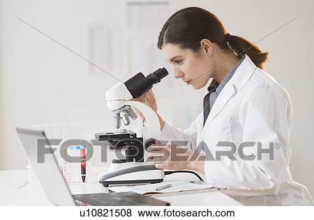 Scientist looking through microscope View Large Photo Image Stock Photo - Scientist looking through microscope. Fotosearch
