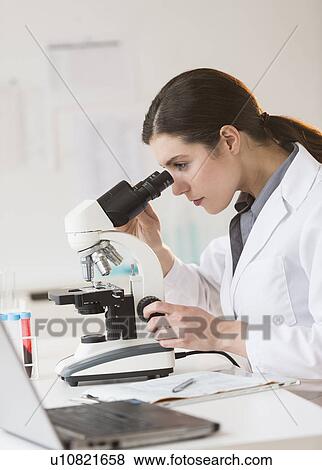 Stock Photo - Scientist looking through microscope. Fotosearch