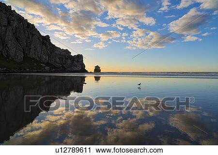 Stock Image - Silhouette of rocks on coast. Fotosearch