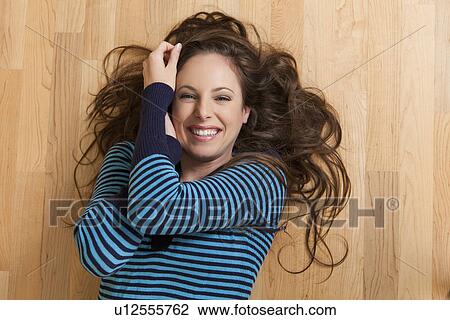 Smiling woman lying on floor, directly above View Large Photo Image Stock Image - Smiling woman lying on floor, directly above. Fotosearch