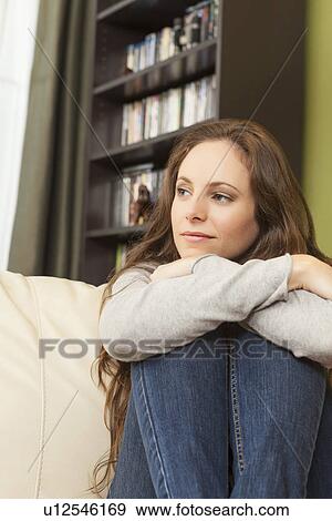 Smiling woman on sofa looking away View Large Photo Image Stock Photo - Smiling woman on sofa looking away. Fotosearch