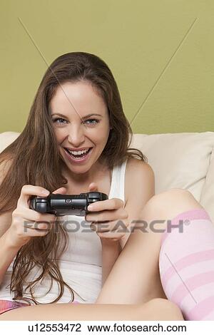 Smiling woman playing video game View Large Photo Image Stock Image - Smiling woman playing video game. Fotosearch