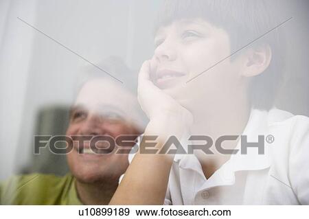 Son (8-9) and father looking through window View Large Photo Image Stock Photo - Son (8-9) and father looking through window. Fotosearch