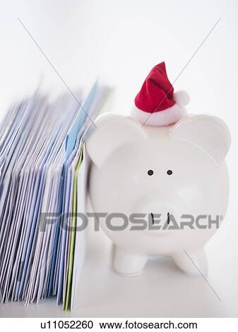 Stock Image - Still life with Santa piggy bank and bills. Fotosearch
