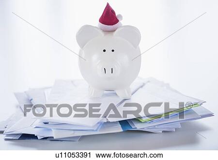 Stock Image - Still life with Santa piggy bank and bills. Fotosearch