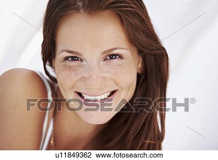 Stock Image - Studio portrait of woman smiling. Fotosearch