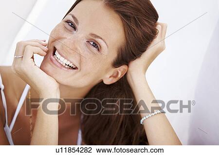 Stock Image - Studio portrait of woman smiling. Fotosearch