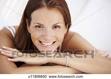 Stock Image - Studio portrait of woman smiling. Fotosearch