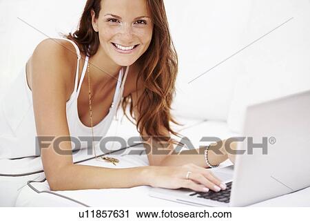 Studio portrait of woman using laptop View Large Photo Image Stock Image - Studio portrait of woman using laptop. Fotosearch