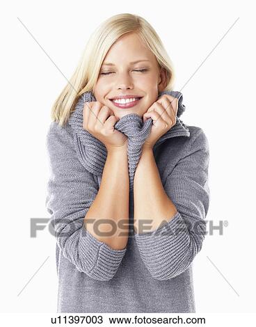Stock Image - Studio portrait of young woman wearing gray sweater. Fotosearch