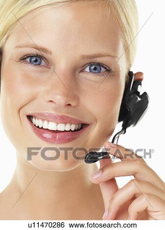 Stock Photograph - Studio portrait of young woman wearing headset. Fotosearch