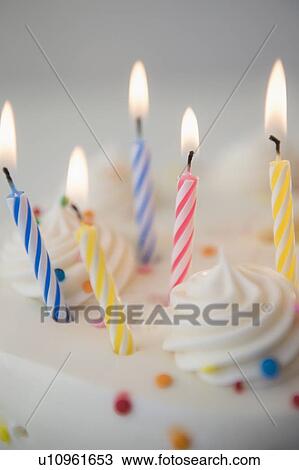 Stock Image - Studio shot of birthday cake with lit candles. Fotosearch