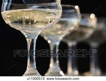 Stock Image - Studio shot of champagne in champagne coupes. Fotosearch