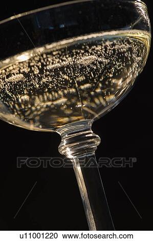 Stock Image - Studio shot of champagne in champagne coupe. Fotosearch