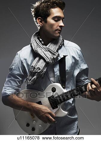 Studio shot of man playing electric guitar View Large Photo Image Stock Photo - Studio shot of man playing electric guitar. Fotosearch